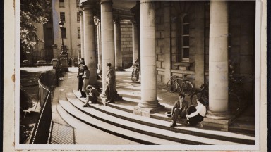 Men and women sitting on the steps of the NLI.