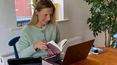 image of blonde haired woman looking at computer screen