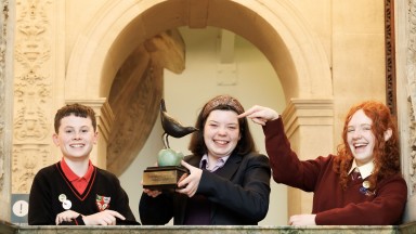 A picture of the three category winners of Poetry Aloud holding the winning trophy.