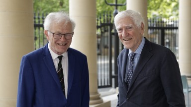 Two men in navy suits standing on steps of the National Library of Ireland
