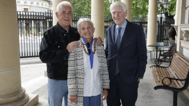Two men and a woman facing camera on steps of National Library