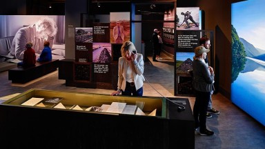 A photo showing the Heaney exhibition with people enjoying the exhibitions