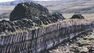 A photo of a bog showing the cuts made into the ground to collect peat.