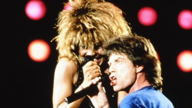 Mick Jagger and Tina Turner performing together on stage at JFK Stadium, Jagger down on one knee