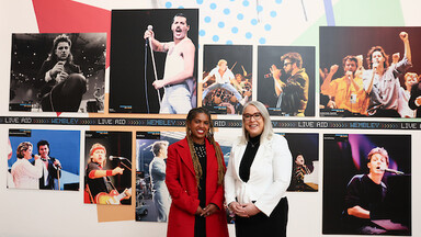 two women in front of images from Live Aid concert