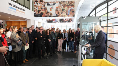 Man speaking from a lectern to a group of people