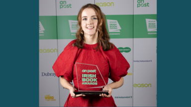 molly in a red dress holding a book award