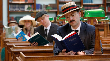 Three people reading Ulysses inside the NLI's Reading Room
