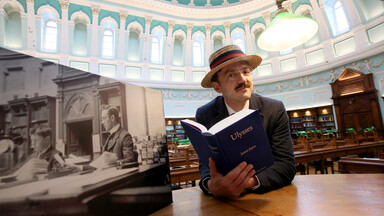 Man dressed as James Joyce reading Ulysses in the reading room