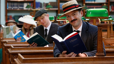 Three people reading Ulysses inside the NLI's reading room