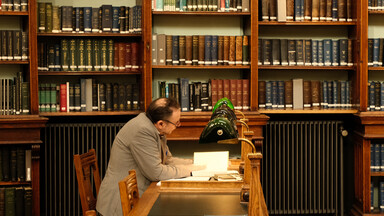 man at reading room table