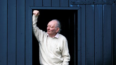 brian friel at his boathouse, standing in the doorway