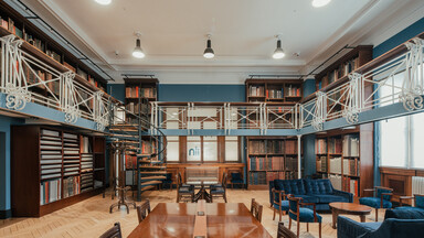 View of the Art Room at the National Library of Ireland. Upper level, with bookcases and blue sofas.