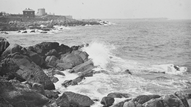 A black and white photo of waves crashing against the rocks in Dublin bay.