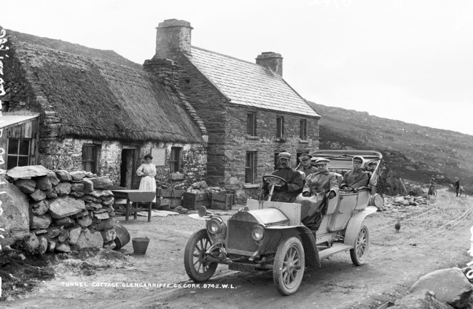 From our Lawrence Cabinet photographs - Tourists motoring past Long Tunnel Cottage, Glengariff, Co. Cork, circa 1906/07. NLI ref. LCAB 08742
