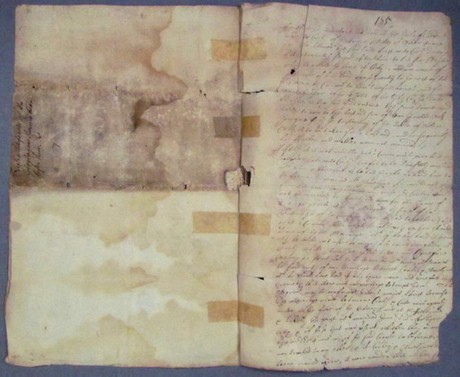 Purple blotches and brown lines are evidence of mould and water damage on historic paper. (GO MS 85 - before treatment)