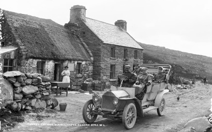 From our Lawrence Cabinet photographs - Tourists motoring past Long Tunnel Cottage, Glengariff, Co. Cork, circa 1906/07. NLI ref. LCAB 08742