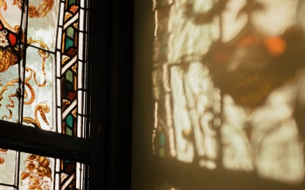 Light and shadows showing through a stained glass window in the NLI's Main Library Building