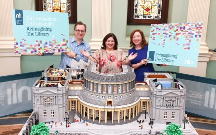 Three people stand behind a Lego model of the National Library of Ireland