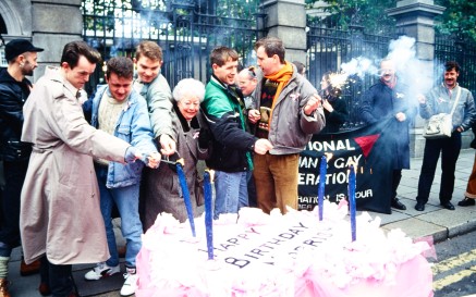 A group of protestors light a giant birthday cake outside the Government building gates