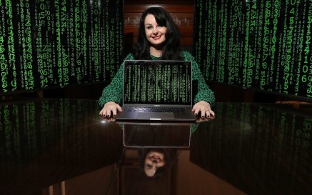 Image of Marian Keyes with laptop and coding background