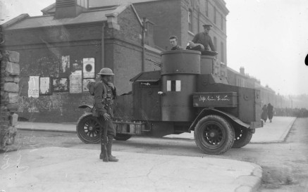 A black and white photo of a soldier standing next to an armoured car at the entrance to Mountjoy Prison 