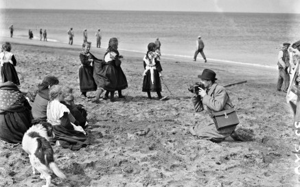 Image of man taking photo of children on the beach