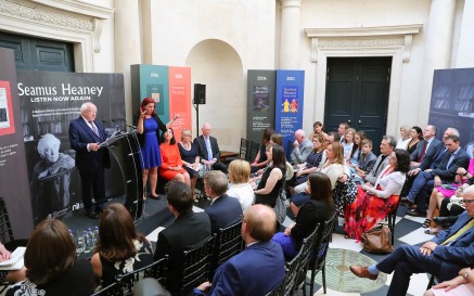 A group of people listening to speech by President of Ireland, Michael D. Higgins at launch of 'Seamus Heaney: Listen Now Again'. An ISL interpreter stands beside the President.