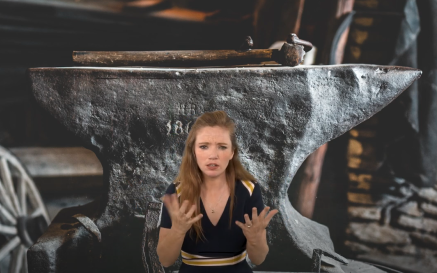 A white woman interpreting a poem. The background image is of an anvil in a blacksmith's forge. 