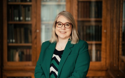 Image of Audrey Whitty in her office with bookshelves behing her