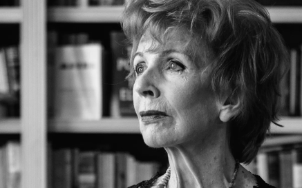 Portrait photograph of Edna O'Brien in front of bookshelves 