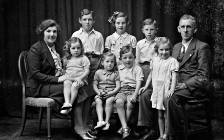 Black and White studio portrait of the Phelan family, featuring both parents and 7 children, ranging in age from about 3 to 10 years of age.