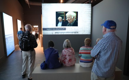 image of a group both sitting and standing enjoying the Seamus Heaney exhibition