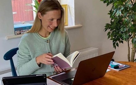 image of blonde haired woman looking at computer screen