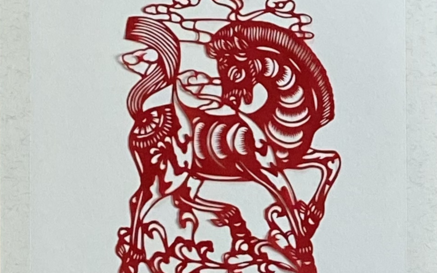 red paper cutting of a decorative horse against a white background 