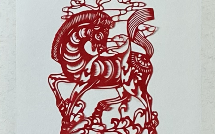 red paper cutting of a decorative horse against a white background 