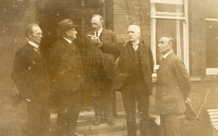 The members of the Boundary Commission standing in a line outside at its first sitting.