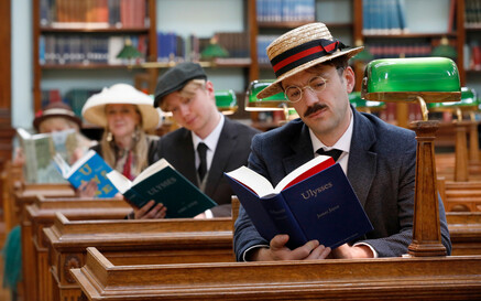 Three people reading Ulysses inside the NLI's Reading Room