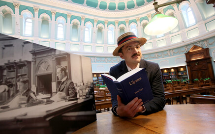 Man dressed as James Joyce reading Ulysses in the reading room