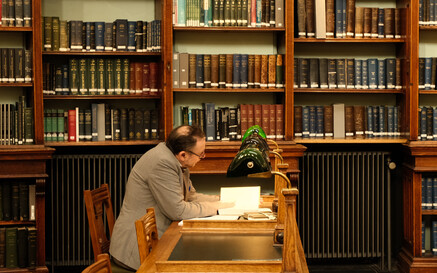 man at reading room table