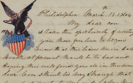 Image of a handwritten letter with an eagle and American flag pendant. 